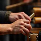 Mãos tocando berimbau e atabaque