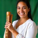Letícia Souza segurando berimbau e sorrindo